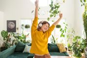 Frau hört Musik in ihrem Wohnzimmer und ist glücklich Frau hört Musik in ihrem Wohnzimmer und ist glücklich